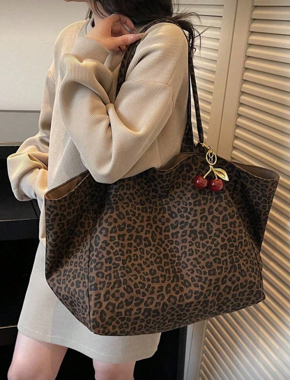 Large Capacity Women's Brown Tote Bag With Red Cherry Pendant. Featuring Leopard Print Design And Sturdy Dual Top Handles For Shoulder Or Hand Carry. Suitable For Storing Daily Essentials Such As Lips